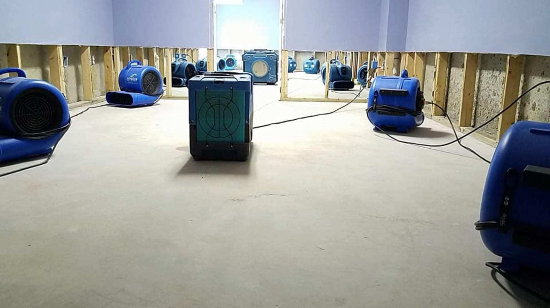 Room with flood-cut drywall drying with air movers and a dehumidifier